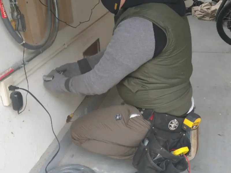 Electrician performing outlet wiring in a Canandaigua garage